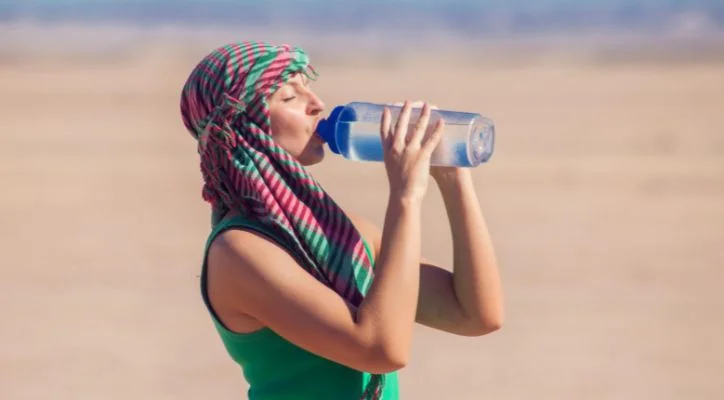 woman drinking water in the desert