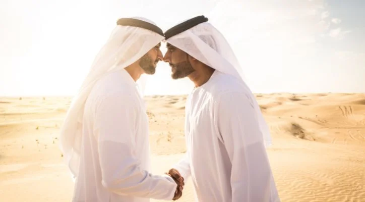 2 Arab men shake hand in the desert